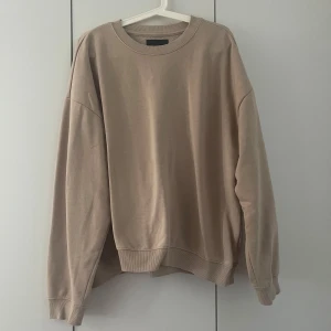 Beige oversized sweatshirt - Beige oversized sweatshirt med rund halsringning och långa ärmar. Enkel och stilren design med ribbade muddar vid ärmslut och nederkant. Sparsamt använd ett fåtal gånger. Storlek XL, oversized/pösig.