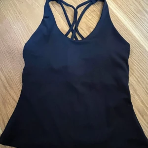 Svart träningstopp från SOC - Säljer en svart träningstopp från SOC med smala korsade axelband i ryggen. Skriv för flera frågor💕.