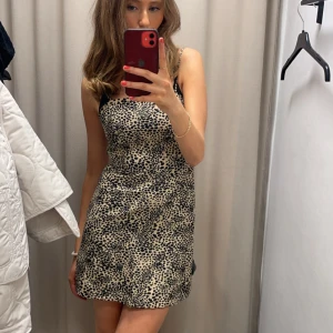 Leopardmönstrad kortklänning  - Säljer en snygg kortklänning med leopardmönster och smala axelband. Klänningen har en rak passform och är. Mjuk och lätt i materialet, passar till många tillfällen🐆storlek XS men passar mig som brukar ha S!