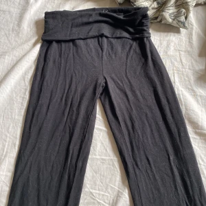 Svarta yoga-byxor med utsvängda ben - Svarta mjuka byxor. Byxorna har utsvängda ben och är gjorda i stretchigt bomullsmaterial, perfekta för yoga eller chill. Snygg och enkel design utan synliga detaljer.
