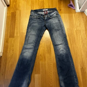Blå bootcut jeans från Fornarina - Snygga blå jeans från Fornarina med bootcut-modell och slitna detaljer.  I storlek 27 med midjemåttet på 37-39cm och innerbenslängd på 86cm. Passar mig bra som är 163 men lite långa nedertill! Dessa bilder är alla bilder jag ger, men annars känn er fria och kontakta vid frågor!