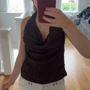 Brun halterneck topp - Snygg halterneck topp i brun färg med öppen rygg😍knappt använd och som nytt skick! Skriv för fler frågor eller bilder! Pris kan alltid diskuteras 💕