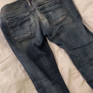 Blå Replay jeans med slitningar - Säljer mina snygga replay jeans, jeansen passar någon som är runt 165 skulle jag säga, jeansen har ett hål vid midjan men som går att sy, även några fläckar vid benen därav priset, dem är straighta/utsvänga då dem är klippta längst ner