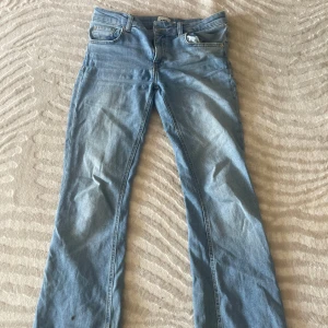 Ljusblå bootcut jeans - Snygga ljusblå jeans med bootcut passform och klassisk femficksdesign. Jeansen har normal midja och är tillverkade i mjukt denimtyg. Perfekta för dig som gillar en retro vibe och vill ha ett par jeans som sticker ut lite extra.
