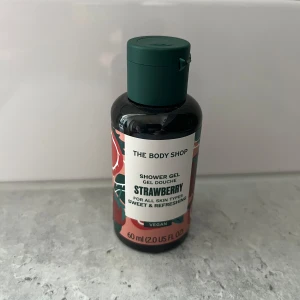 The Body Shop Strawberry Shower Gel - Söt och fräsch duschgelé med jordgubbsdoft från The Body Shop. Kommer i en smidig 60 ml plastflaska med grön kork och färgglad etikett. 