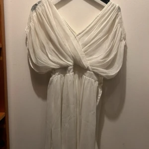 Vit omlottklänning med volang från bubbleroom 36 - Fin vit klänning med omlottliv och voluminösa ärmar. Klänningen har v-ringning och är tillverkad i ett lätt, skirt material som ger ett drömmigt intryck. Perfekt för sommarens speciella tillfällen. Passar perfekt till student eller konfirmation💕från bubbleroom storlek 36