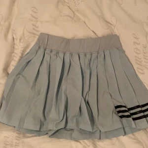 Snygg blå padel kjol - Super snygg padel kjol från adidas, har en vattenfläck på framsidan nu men kommer att torka sen! Ifall man vill se så den inte finns kvar så skriv till mig! Säljer då jag har för många sånna! Det finns inbyggda shorts! Priset kan diskuteras!💞