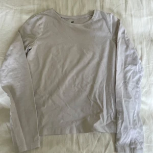 Långärmad tröja  - En långärmad tröja i storlek 134/140. Blivit lite mörkare efter tvättar. Har en liten fläck på baksidan