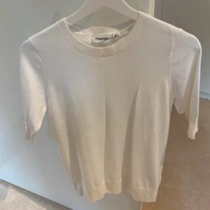 Vit kortärmad tröja från Kappahl - En stilren vit tröja från Kappahl i storlek XL. Tröjan har rund halsringning, korta ärmar och är tillverkad i mjukt material som känns skönt mot huden. Perfekt för dig som gillar en clean och enkel look.