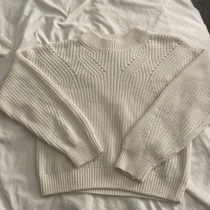 Vit stickad tröja från H&M - Säljer en krämvit stickad tröja från H&M. Tröjan har rund hals och långa ärmar, perfekt för lager på lager under kyliga dagar. Enkel att matcha med jeans eller kjol för en clean look.