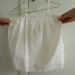 Vit linnetopp - Säljer en luftig vit linnetopp med smala, justerbara axelband som korsas i ryggen. Toppen har resår både upptill och nedtill för en skön passform och är perfekt för sommaren! Enkel och snygg design som är lätt att matcha! 🤍🤍