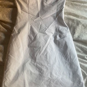 Vit kort klänning från BikBok XS - Snygg vit kort klänning från BikBok i storlek XS. Klänningen är figurnära med enkel design och sömmar som framhäver siluetten. Perfekt för dig som gillar stilrena och fräscha outfits.