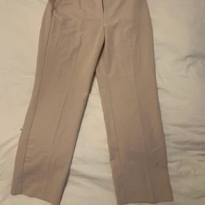 Beige kostymbyxa  - ljus beiga kostymbyxor från nakd!  Skulle säga att de är en rak modell på byxor. Knappt använda, i storlek S  