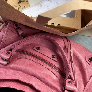 Balenciaga city bag - Säljer min balenciaga city i medium. Rosa och i fint skick. Har en liten defekt men annars färsch. Köp direkt för 3000. Pris kan snackas också så kom med bud💘 Skriv snälla bara om ni är intresserade påriktigt!!!