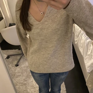Fin stickad tröja  - Fin v-ringad beige stickad tröja ifrån vero Moda i bra skick!