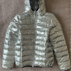 Champion jacka i silver  - Jag säljer min silvriga Champion jacka som är nästintill ny då den endast använts ett fåtal gånger.   Jackan är köpt på Champion girls och är därför i storlek 14 år / 162-167 cm men passar mig som är en small i vanliga fall. 