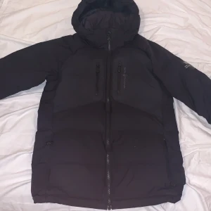 Saol racing jacka,barn - Sail racing jacka med bara svarta detaljer, storlek 170, barn/ungdom. lite stor i storlek, köptes på hemsidan för 2800 säljer för ca halva priset. Har dock ett litet hål under armen som ej syns. 