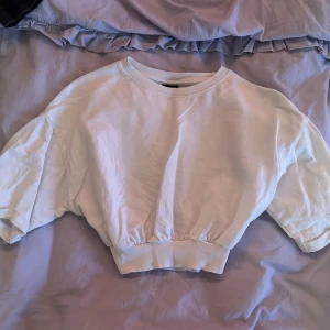 Croptop - En vit magtröja som går in vid midjan. Perfekt till träning eller vardag! Bra skick!