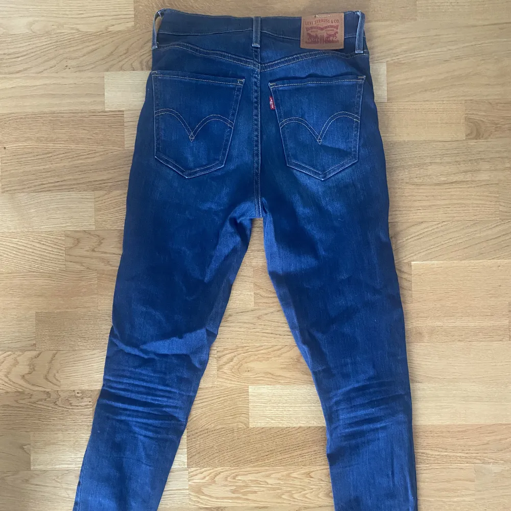 Mörkblå jeans ifrån Levi’s i modell Mile High Super Skinny. Knappt använda så i superfint skick. Storlek 26, jag är en 36a och passar på mig. . Jeans & Byxor.