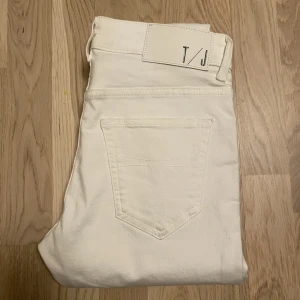 Tiger of Sweden vita jeans - Säljer ett par helt oanvända vita Tiger of Sweden jeans. OBS en liten fläck vid knappen, se bild två. Byxorna är endast testade. En tight modell men stretchiga. Storlek- 29/32. Alltså 29 i midjan och 32 i benlängden.  Färg- vit