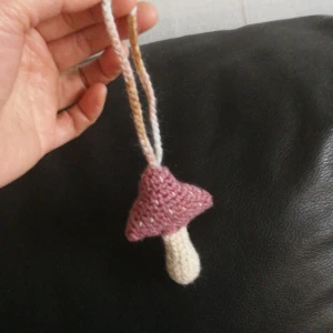Unika /virkade Svamp hänge  - En söt hänge av svamp. Kan hänga på väska. Nyckel mm. Både sidan se likadant ut. Svamp är 6cm *9cm utan hängsnör. Fyllning av polyfiber. Jag samfraktar gärna. Fotobevis skickar jag alltid till köpare. 
