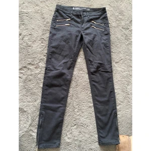 Snygga svarta jeans med dragkedja - Jättesnygga jeans med dragkedjor nere vid benen, går att öppna elr ha dom stängda, Oanvända då dom var för små. Skinny low waist. Storlek 29 motsvarar M Tyvärr inte så mycket stretch