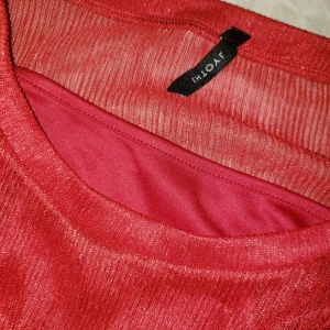 Glittrig röd topp - Tunn tröja med ett linne under. Se bild 3. Trekvartsärmar.