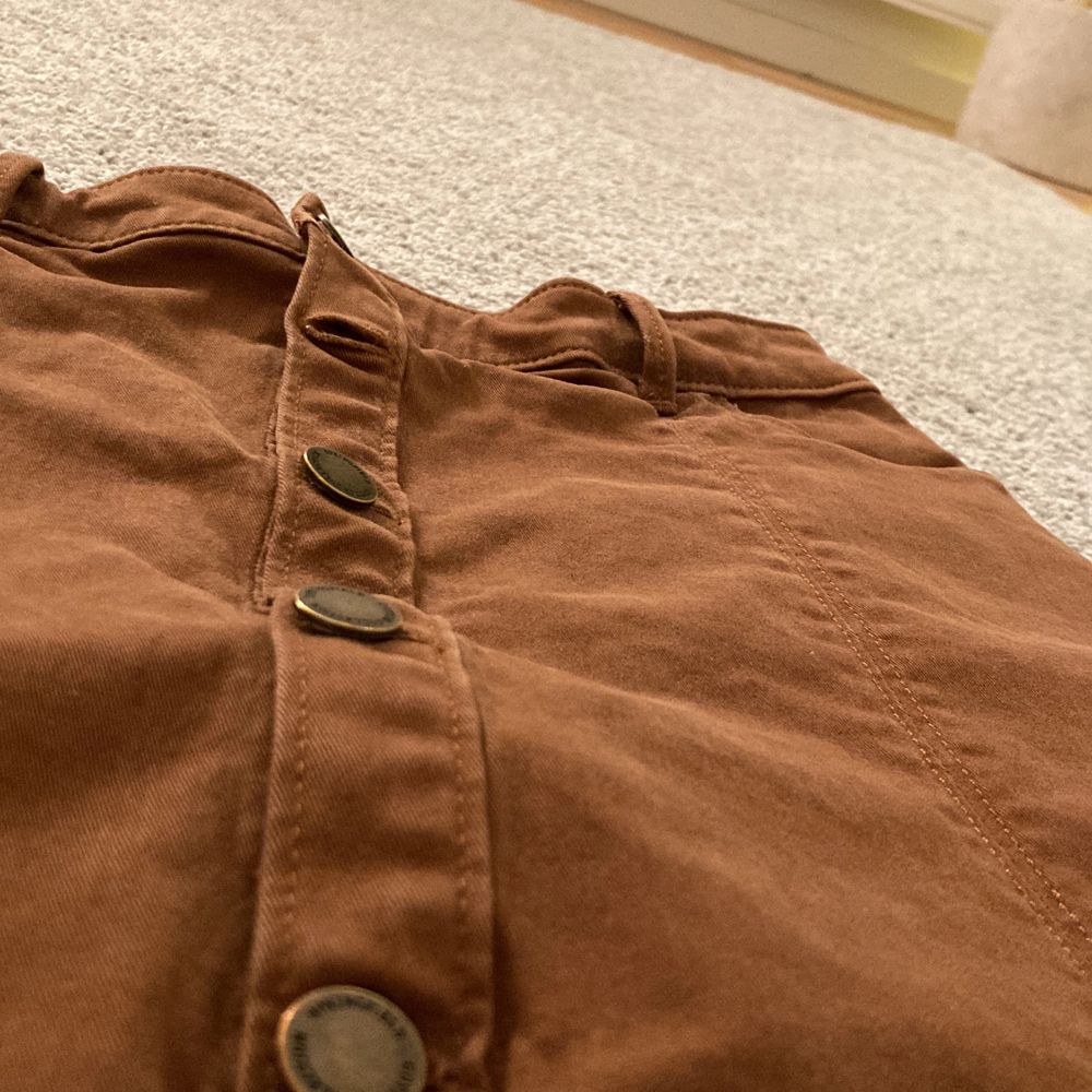 En brun superfin kjol i fint skick! Med silvriga knappar och fina sömmar om detaljer.. Kjolar.