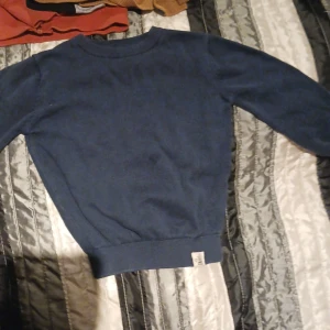 Stickad tröja barn - Stickad mörkblå tröja i storlek 86, använt skick.