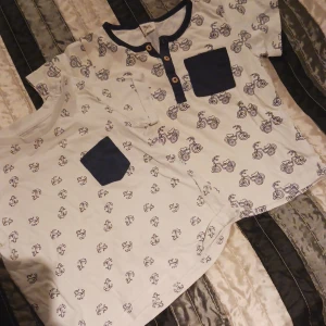 2 t-shirtar barn - 2 mönstarade vita t-shirtar med olika motiv, storlek 86, använt skick