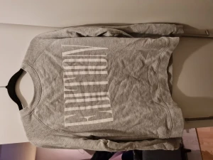 Grå Sweatshirt - Grå sweatshirt med vit text i strlk Small.