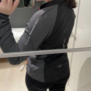 Träningsjacka - Svart/grå/orange träningsjacka eller tunn vindjacka från SOC. Flera fickor och väldigt skön. Storlek 36 (passar en 38 också)