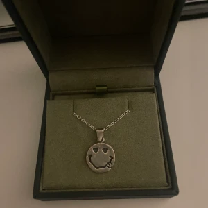 Smiley halsband  - Halsband med en smiley. 😋Vet ej märke! Säljer endast berlocken och ibte själva halsbandet. Köptes på Plick för 700kr säljer för 400kr. Köparen står för frakten💓