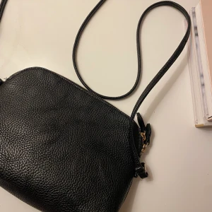 väska - svart väska med guld detaljer från h&m, använd fåtal gånger men ingen skada skedd