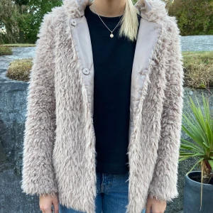 Beige jacka - Gosig höstjacka i mkt fint skick från Freequent i stl xs. Jackan har en luva och är smyckad med guld/svart randig revär på sidan. Jackan har sidofickor och stängs med tryckknappar. Frakt 66kr 💕