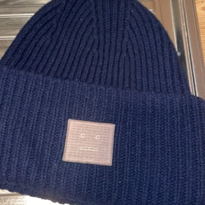 Acne Mössa - Acne Mössa Köpt på acnes butik på NK  Marinblå med rosa märke  Budgivning om flera är intresserad/ högsta bud  One size (56) 