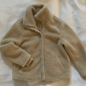 Pilejacka H&M  - Beige jacka med dragkedja, fickor, mudd i ärmslut & hög krage. 