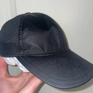 Gucci nylon cap - Hej säljer nu min Gucci nylon cap i befintligt skick kvitto och box saknas men lappen i finns kvar samt en av knapparna där bak har lossnat där av priset                                             Kepsen är stl M/ 57-58cm