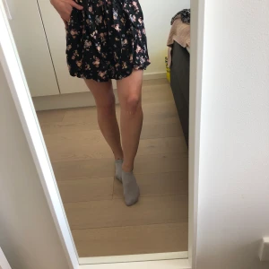Svarta kjol med Blom-mönster - Snygg men välanvänd kort kjol i svart med Blom-mönster. Inte sliten men syns att den är använd. Fickor på sidorna. Superskön och smidig att bara dra på pga resorband i midjan.