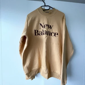NEW BALANCE SWEATSHIRT M - Sweatshirt från New Balance i storlek M. Väldigt true to size sitter som den ska varken mindre eller större i storleken. Stort tryck på bröstet och ett mindra vid nacken. I en fin kamelfärg. Använd endast en gång. 