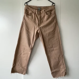 Beige Jeans stretch  - Ett par beiga jeans i stretch material. Mycket bekväma på. Sitter åt vid låren lite och mer lösa i slutet av bena. Effekt av klippta jeans längst ner.