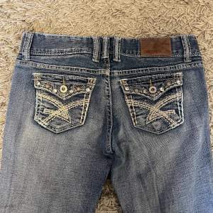 Lågmidjade bootcut jeans med snygga fickor. Tyvärr för korta. Midjemått- 79cm, Innerbenslängd- 75cm 