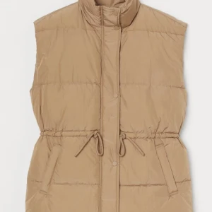 Beige väst - Använd en gång pga för liten.  Man kan dra åt den i midjan. Superfin och varm väst! Strl XS, passar också en S.   Finns i Kristineberg eller kan skickas mot fraktkostnad 