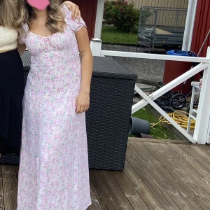 Blommig långklänning  - Klänning med slits från BikBok. Perfekt för midsommar! Använd endast en gång.