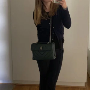 Sjukt fin mörkgrön Kurt geiger väska  - Säljer min sjukt fina Kurt geiger väska!!! Väskan har lite tecken på användning (sista bilden) då ägaren innan inte berättade. Men absolut inget man tänker på eller ser bra eftersom de är på undersidan, i ett hörn. Invändigt är den så gott som ny!!! 