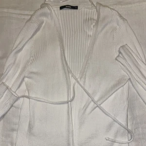 En vit topp - En vit topp från bikbok. Den är av mjuk material och den har varit använd ett fåtal gånger.