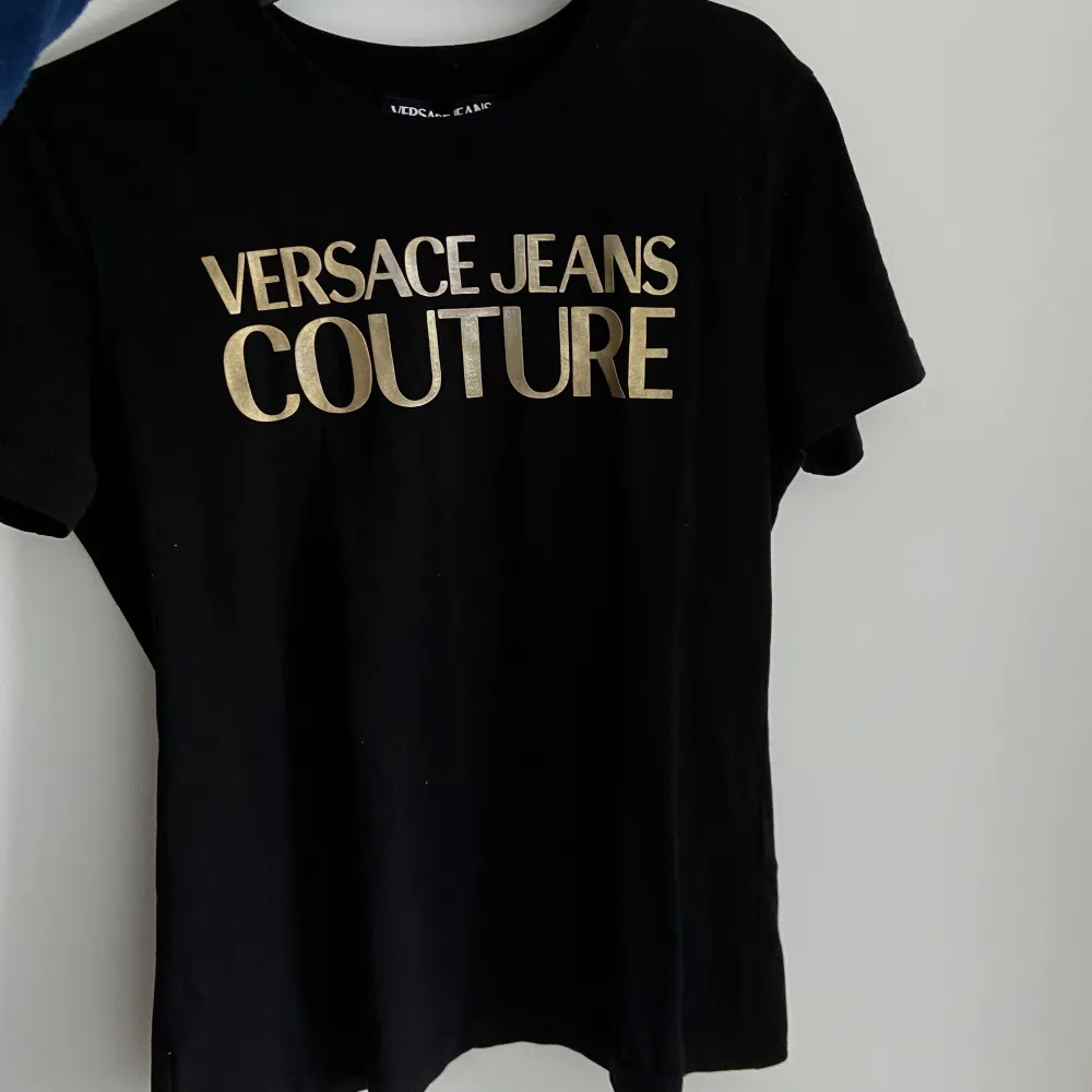 Svart och guldiga Versace T-shirt i storlek S.. T-shirts.