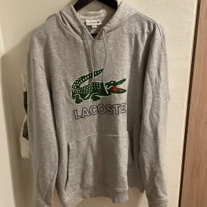 Lacoste hoodie strl L - Säljer min gråa Lacoste hoodie i bra skick! Köparen står för frakt!