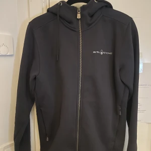 Sail Racing Zip Hoodie - En fin Sail Racing zip i 10/10 skick,  använt fåtal gånger. Storlek S och mörk marin blå. Nypris 1300kr