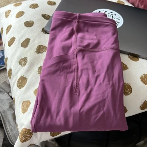 Lululemon tights - Tror att det är modellen Fast and Free High-Rise Tight 25" i färgen: Moonlit Magenta. Använda ca 2-3 gånger, super fräscha i jätte bra skick.